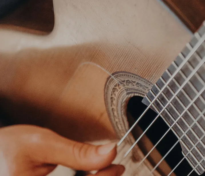 Manos sobre el diapasón de la guitarra